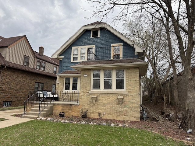 view of front facade featuring brick siding and a front yard