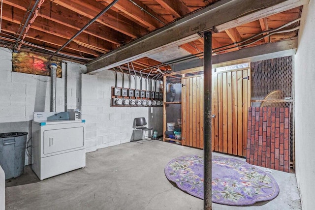 unfinished basement with concrete block wall and washer / dryer