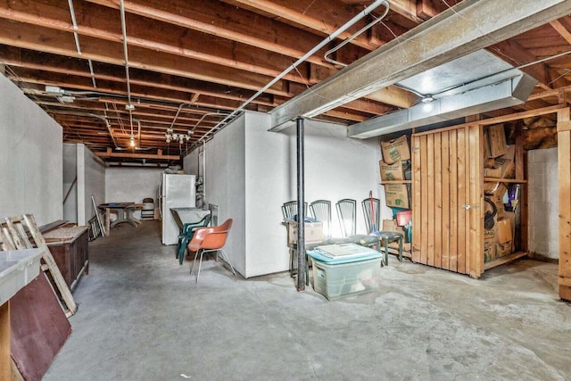 unfinished below grade area featuring freestanding refrigerator
