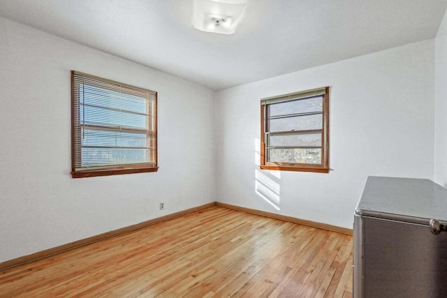 empty room featuring light wood finished floors and baseboards