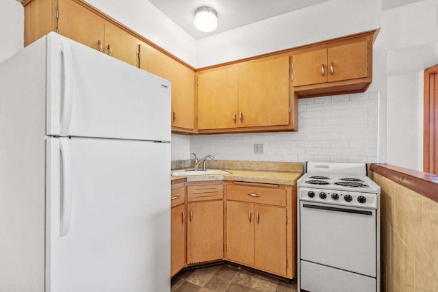 kitchen featuring light countertops, a sink, decorative backsplash, and white appliances