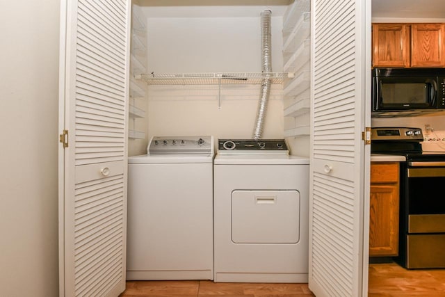 washroom featuring light wood-style floors, separate washer and dryer, and laundry area