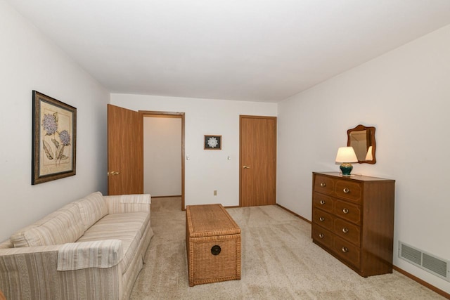 living area with visible vents and light carpet