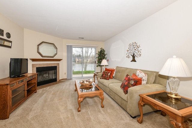 carpeted living room featuring a tile fireplace and a water view