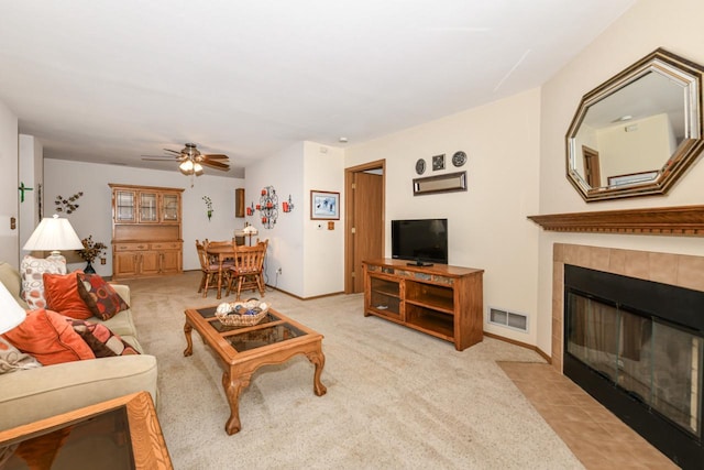 living area featuring a ceiling fan, visible vents, light carpet, and baseboards