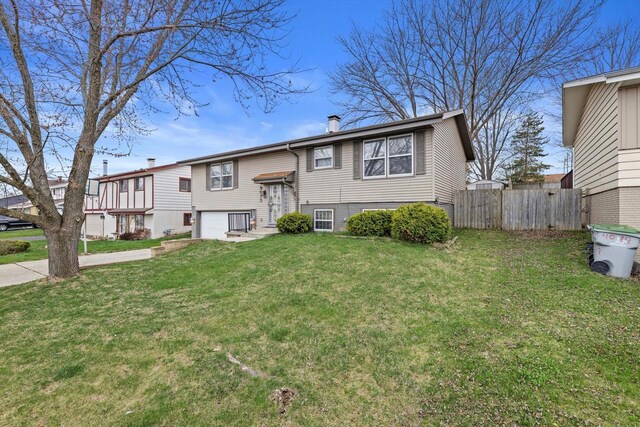 9073 N Joyce Ave, Milwaukee, WI 53224 - view of front of property with a front lawn, an attached garage, concrete driveway, and fence