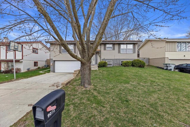 9073 N Joyce Ave, Milwaukee, WI 53224 - bi-level home with a front yard, an attached garage, and concrete driveway
