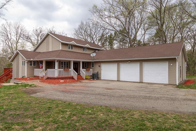 view of front of property featuring covered porch, aphalt driveway, and a garage