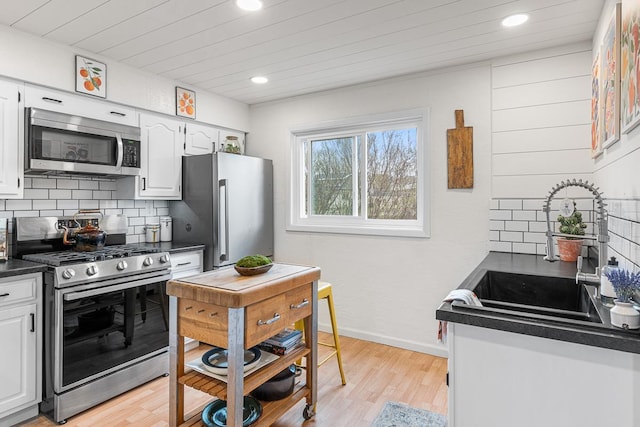 kitchen featuring recessed lighting, tasteful backsplash, dark countertops, and stainless steel appliances