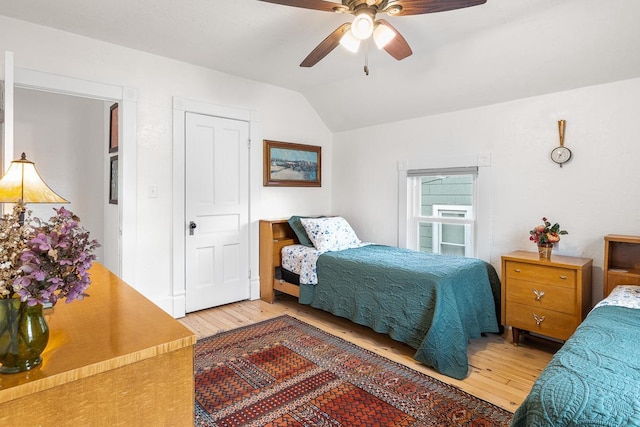 bedroom with a ceiling fan, vaulted ceiling, and hardwood / wood-style floors