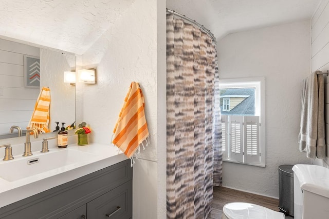full bathroom featuring vanity, wood finished floors, lofted ceiling, toilet, and a shower with shower curtain