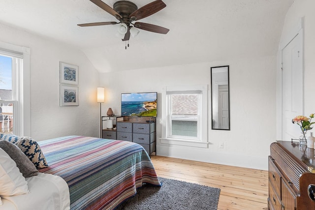 bedroom with baseboards, ceiling fan, vaulted ceiling, and hardwood / wood-style flooring