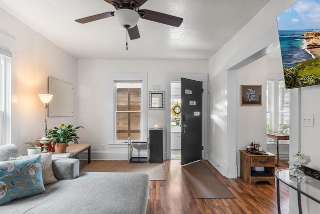 living room with baseboards, a ceiling fan, and wood finished floors