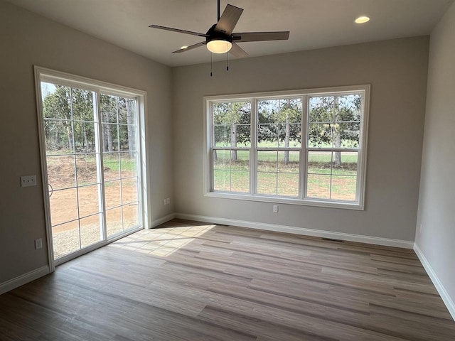 spare room with recessed lighting, a ceiling fan, visible vents, baseboards, and wood finished floors