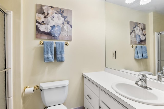 bathroom featuring a shower with door, toilet, and vanity