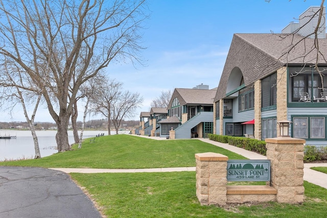 surrounding community featuring a lawn and a water view
