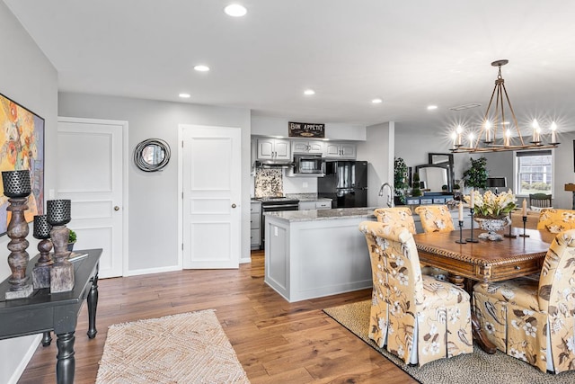 dining area with recessed lighting, a notable chandelier, and light wood-style floors