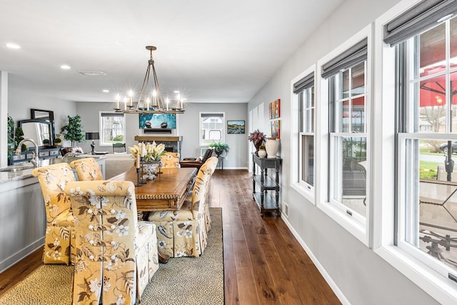 dining area with dark wood-style flooring, recessed lighting, a notable chandelier, and baseboards