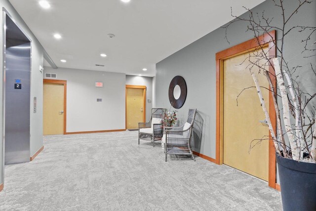 interior space featuring visible vents, baseboards, elevator, recessed lighting, and carpet flooring