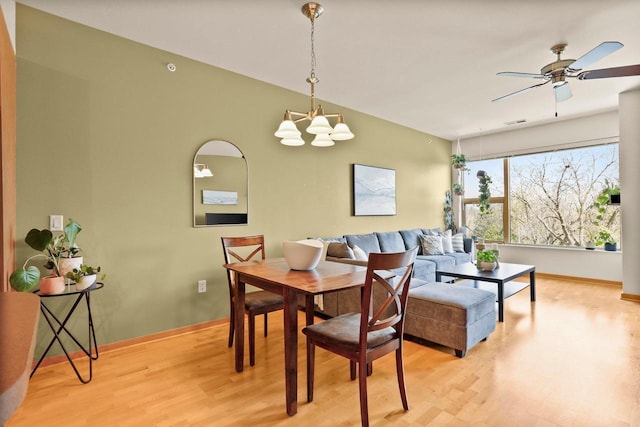 dining area with baseboards, light wood-style flooring, ceiling fan with notable chandelier, and visible vents