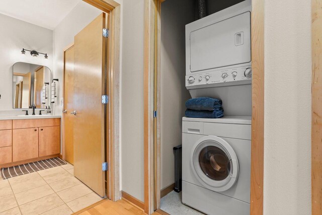 laundry room featuring stacked washer and dryer, laundry area, and a sink