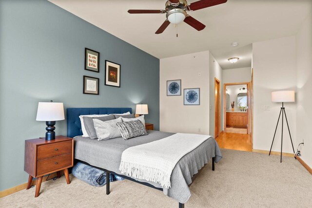 carpeted bedroom featuring baseboards, a ceiling fan, and ensuite bathroom