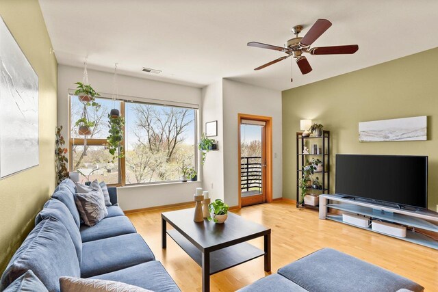 living area with a ceiling fan, baseboards, visible vents, and light wood-style flooring