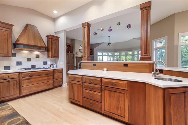 kitchen featuring gas cooktop, custom exhaust hood, a sink, and decorative columns