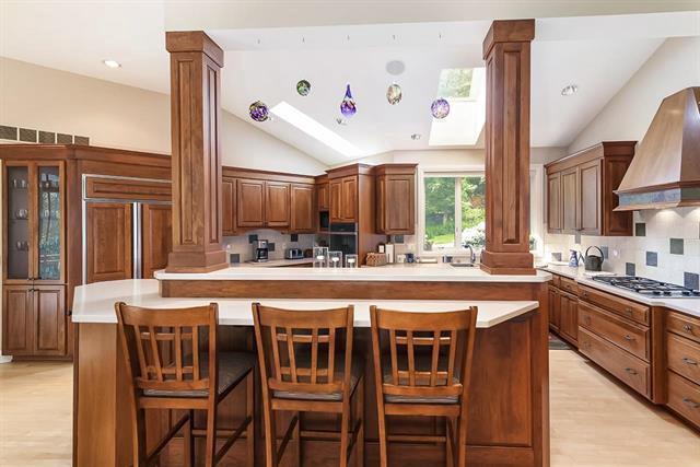 kitchen with stainless steel gas stovetop, decorative columns, and vaulted ceiling