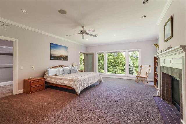 bedroom with a fireplace, ornamental molding, carpet flooring, and baseboards