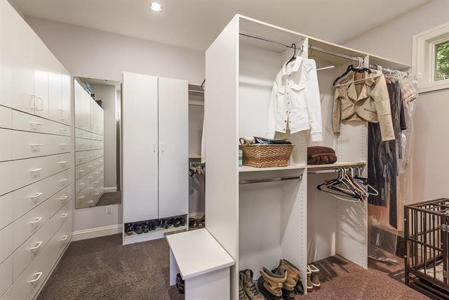 walk in closet with dark carpet