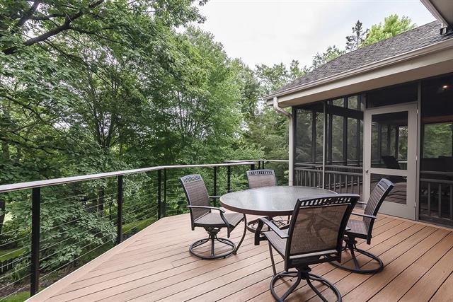 deck featuring a sunroom and outdoor dining area