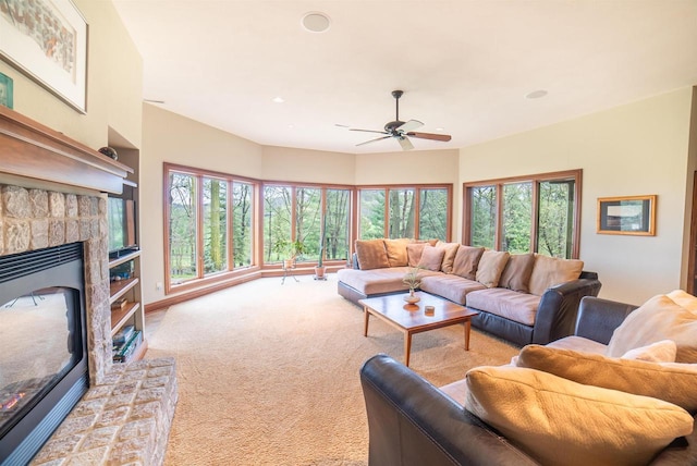 living area with a ceiling fan, carpet flooring, and a fireplace