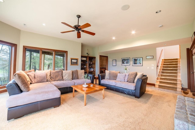 living room featuring light colored carpet, stairway, ceiling fan, and recessed lighting