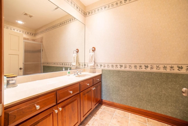 full bathroom featuring an enclosed shower, vanity, visible vents, and wallpapered walls