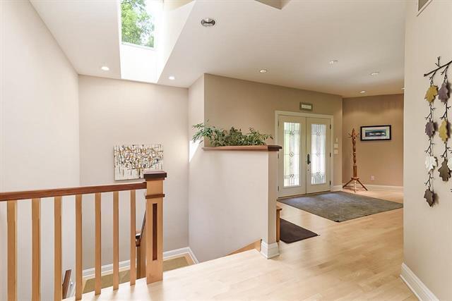 foyer entrance featuring french doors, baseboards, visible vents, wood finished floors, and a skylight