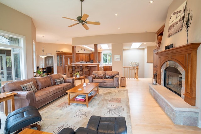 living area featuring recessed lighting, light wood-style flooring, a ceiling fan, and a glass covered fireplace