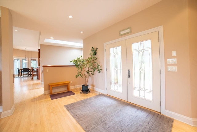 foyer featuring baseboards, french doors, recessed lighting, and light wood-style flooring