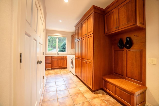 laundry area featuring recessed lighting, light tile patterned floors, a sink, washer / dryer, and cabinet space