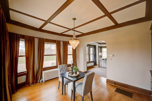 1324 Washington Ave, Oshkosh, WI 54901 - dining area featuring visible vents, radiator, arched walkways, coffered ceiling, and a notable chandelier