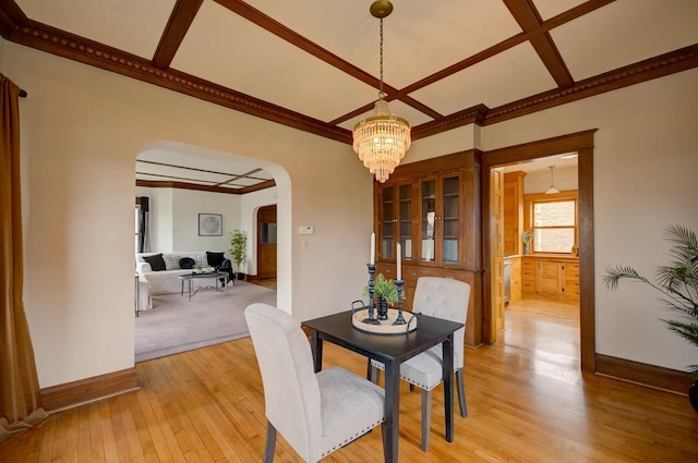 1324 Washington Ave, Oshkosh, WI 54901 - dining area featuring arched walkways, baseboards, a chandelier, light wood-style floors, and coffered ceiling