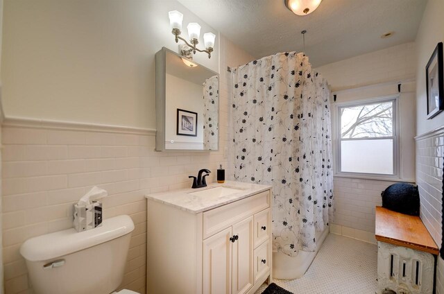 1324 Washington Ave, Oshkosh, WI 54901 - full bath featuring tile walls, tile patterned flooring, curtained shower, vanity, and toilet