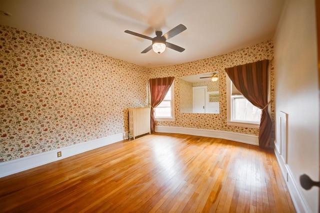 1324 Washington Ave, Oshkosh, WI 54901 - additional living space featuring wallpapered walls, radiator heating unit, and light wood-style flooring