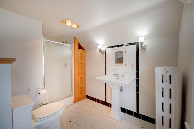 1324 Washington Ave, Oshkosh, WI 54901 - bathroom with baseboards, radiator, toilet, and a shower stall