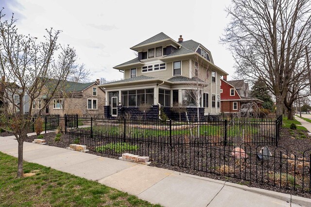 1324 Washington Ave, Oshkosh, WI 54901 - american foursquare style home featuring fence private yard, roof with shingles, a chimney, and a sunroom