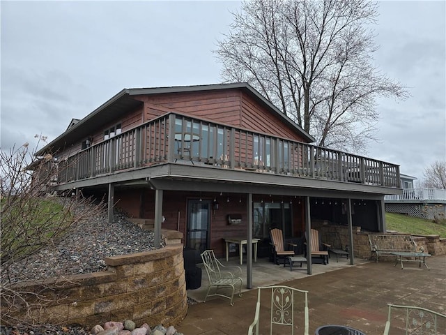 back of house with a deck and a patio area