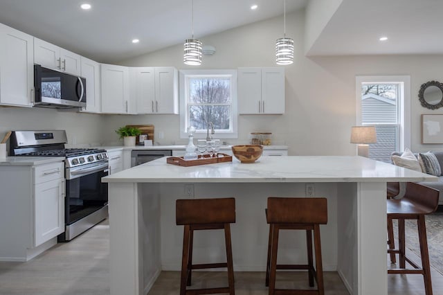 3326 6 Mile Rd, Racine, WI 53402 - kitchen featuring recessed lighting, a healthy amount of sunlight, appliances with stainless steel finishes, and a kitchen bar