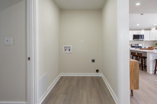 3326 6 Mile Rd, Racine, WI 53402 - laundry area with hookup for an electric dryer, visible vents, light wood-style flooring, and washer hookup