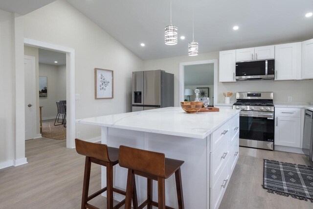 3326 6 Mile Rd, Racine, WI 53402 - kitchen with a breakfast bar area, white cabinetry, light wood-style floors, stainless steel appliances, and a kitchen island