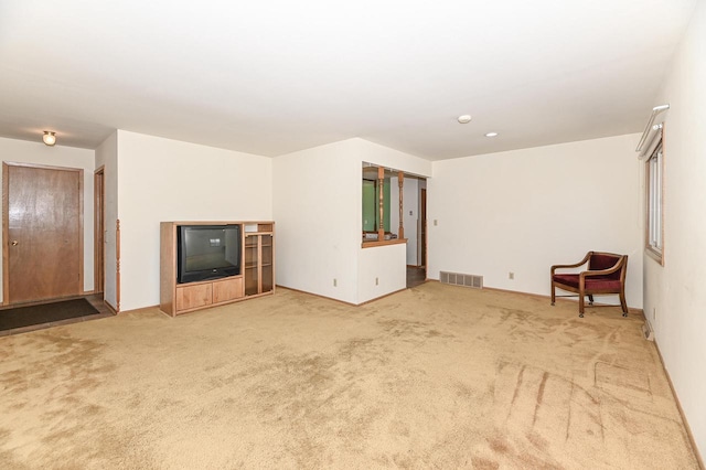 unfurnished living room featuring visible vents, baseboards, and carpet floors
